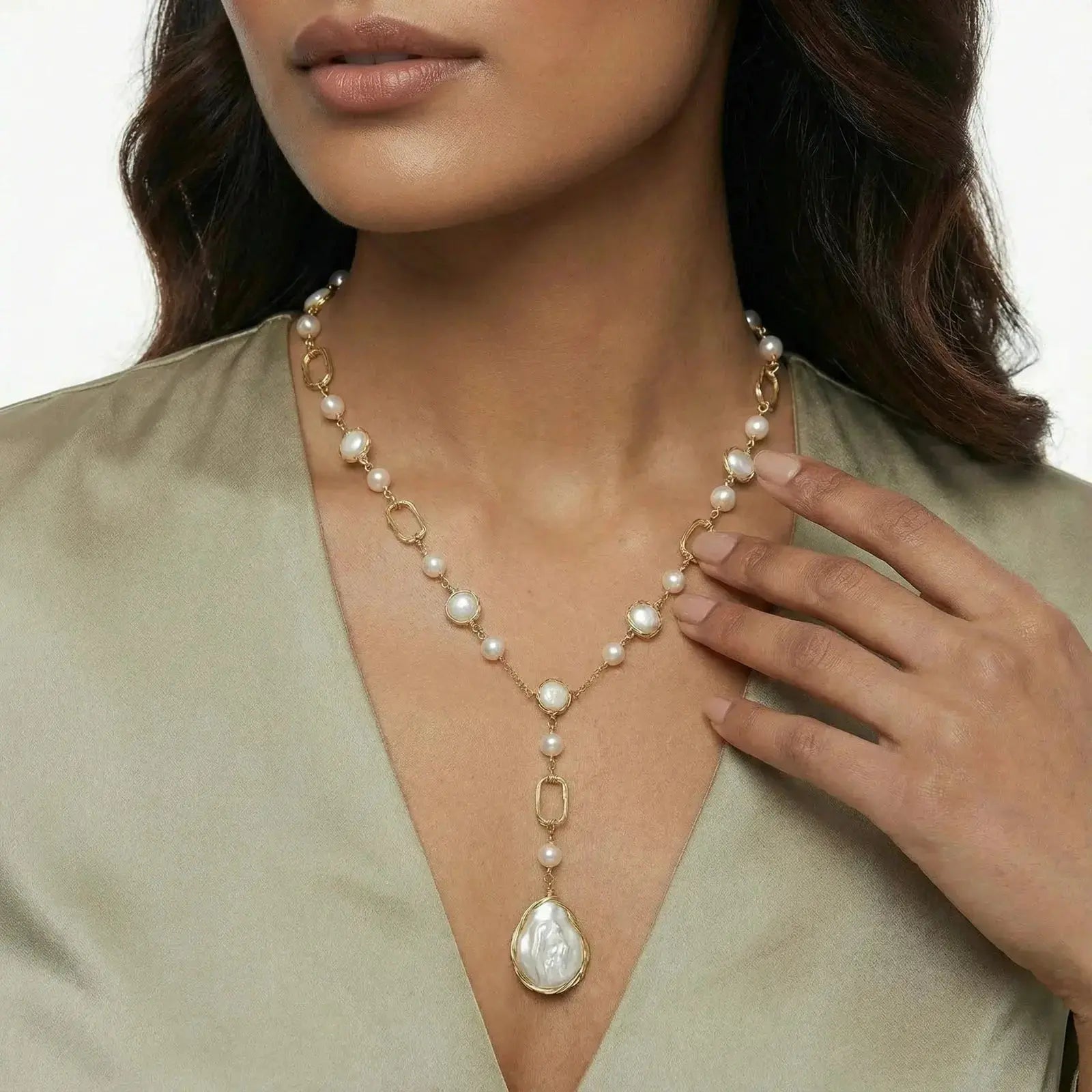 Woman wearing a gold and pearl drop necklace with baroque pendant, elegant jewelry