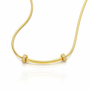 A gold snake chain necklace with a curved bar centerpiece, accented by two small square bezel-set crystal clusters on either end, shown on a white background with a soft reflection.
