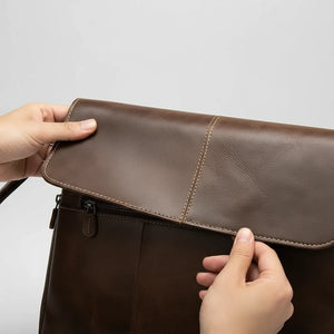 Archer unisex oil-wax leather crossbody messenger in coffee brown, worn across the body on a city street