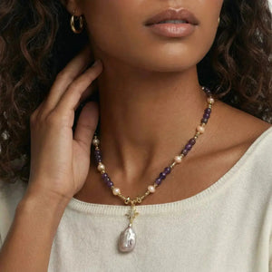 Woman wearing a gold amethyst and pearl necklace with large baroque pearl pendant