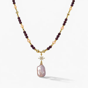 Gold amethyst pearl necklace with star pendant and large baroque pearl drop on white background
