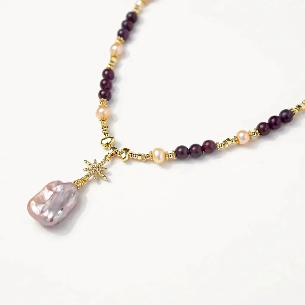 Gold necklace with amethyst beads, pearl accents, and a large baroque pearl pendant
