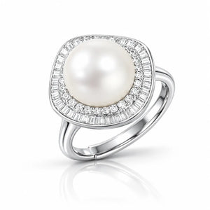A silver ring featuring a large, round white pearl surrounded by a halo of small clear baguette and round-cut stones, set on a polished silver band.