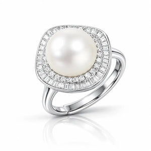 A silver ring featuring a large, round white pearl surrounded by a halo of small clear baguette and round-cut stones, set on a polished silver band.