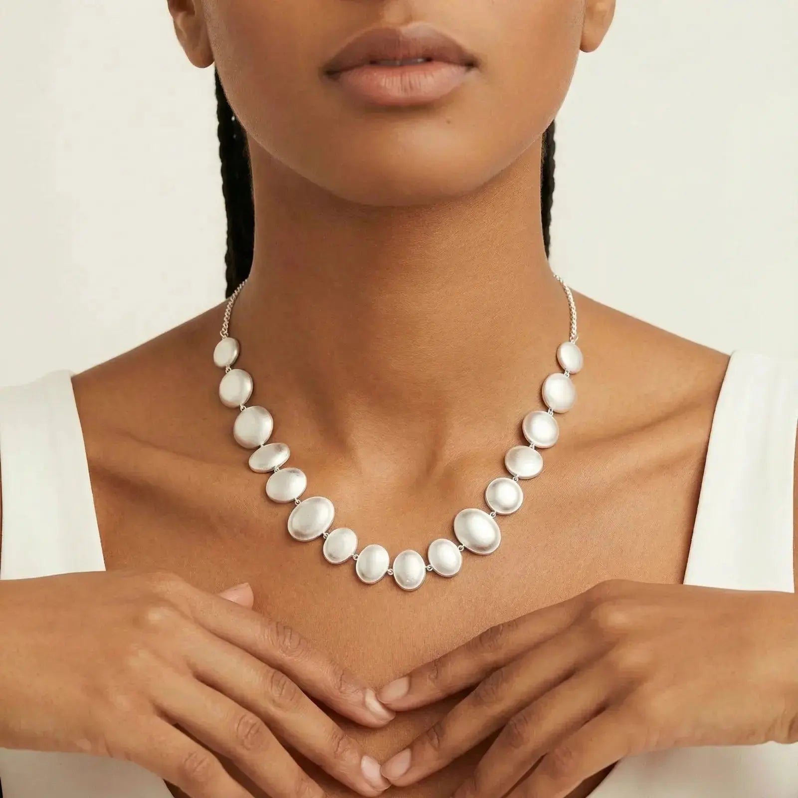 Woman wearing a sterling silver statement necklace with oval white pearls