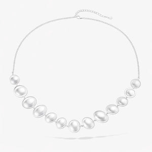 Sterling silver statement necklace with graduated pearl-like oval links on a white background