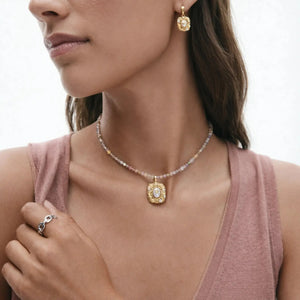 Woman wearing an 18K gold gemstone pendant necklace and matching gold earrings