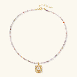 Necklace with multicolored beads and a gold pendant on a white background