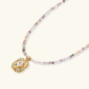 Necklace with a gold pendant and multicolored beads on a white background