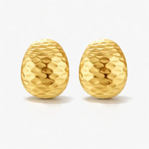 Hammered gold huggie earrings with textured finish on a white background