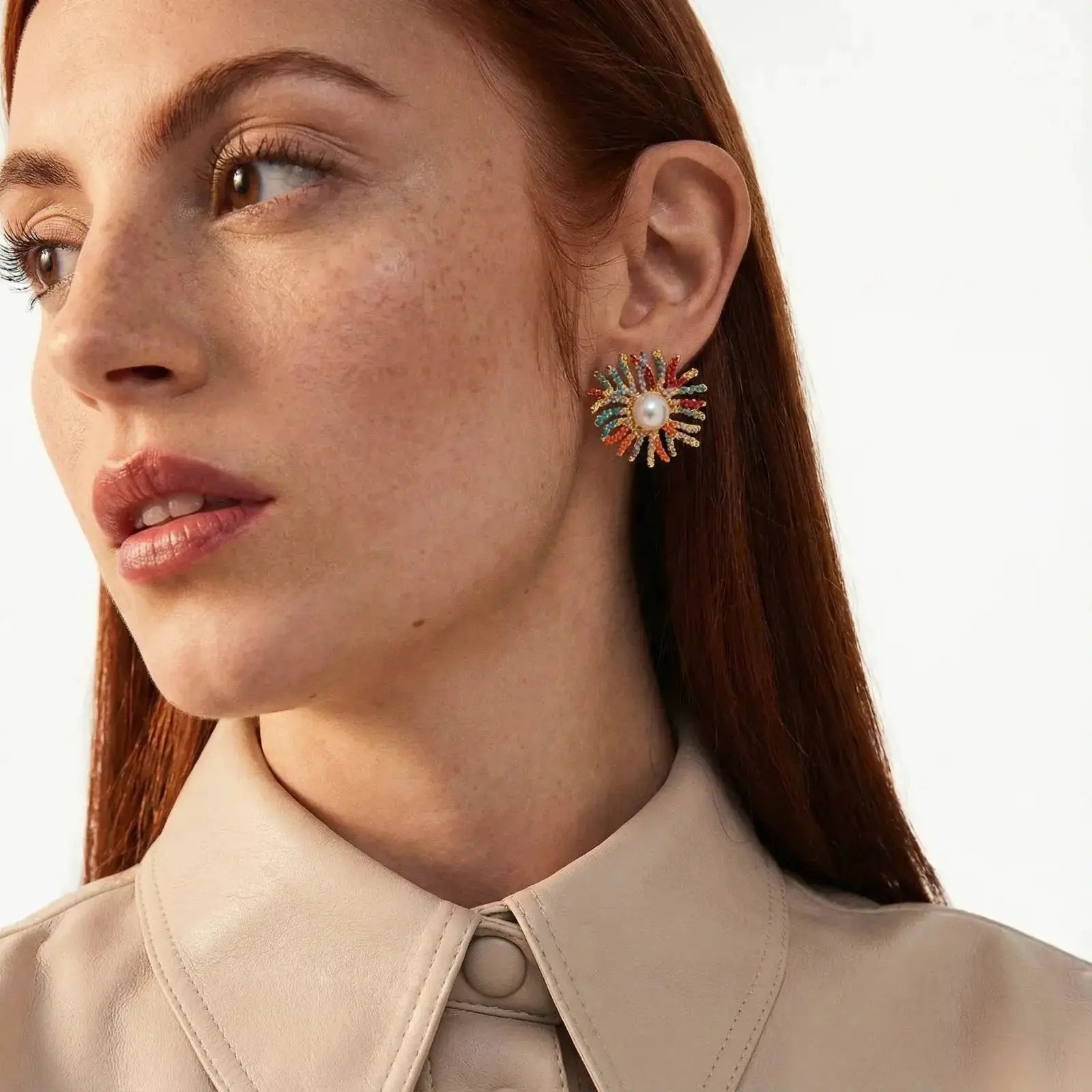Close-up of a woman wearing colorful earrings with a neutral background