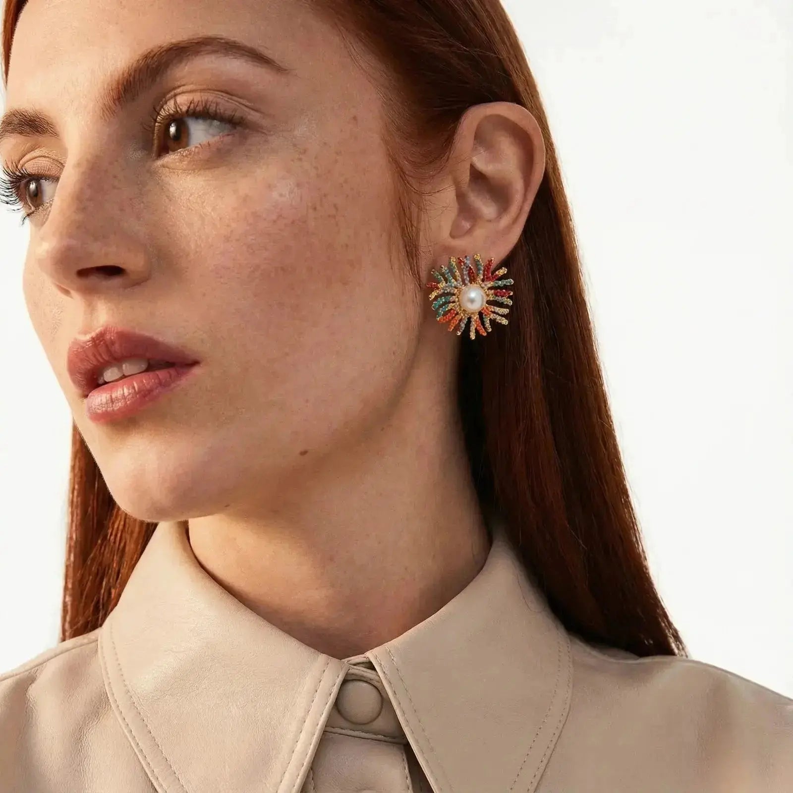 Woman wearing colorful pearl burst stud earrings, close-up on ear and earring detail
