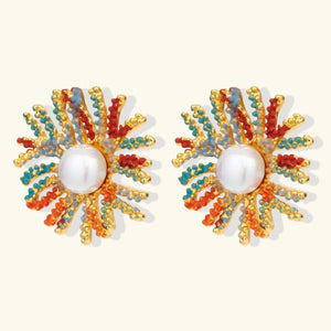 Pair of earrings with pearl center and colorful beadwork on a white background