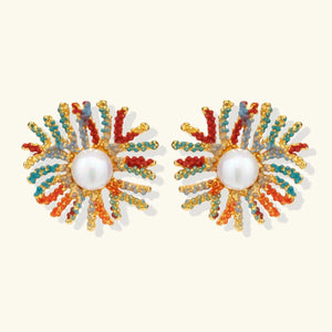 Pair of colorful beaded earrings with pearl center on a white background