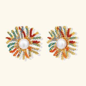 Pair of colorful sunburst earrings with pearl center on a white background