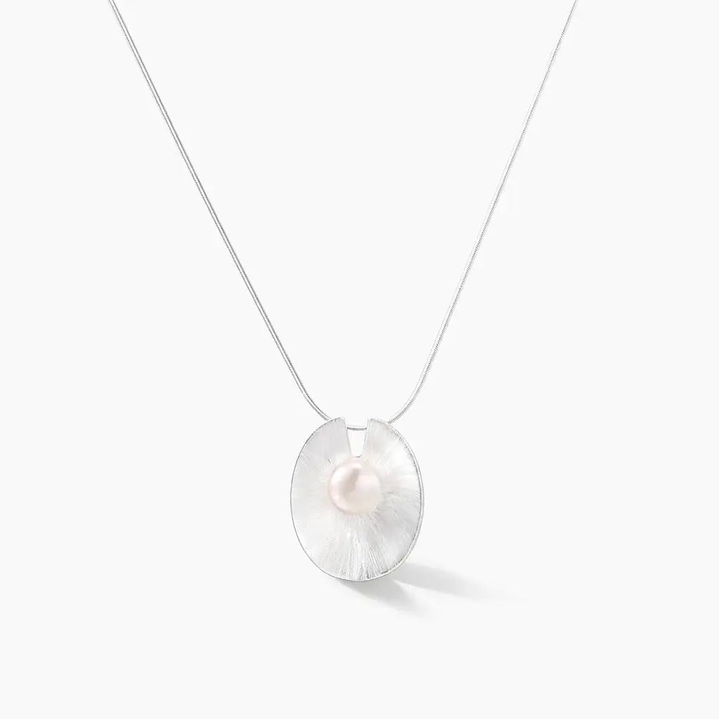 Sterling silver necklace with round disc pendant and central white pearl on white background