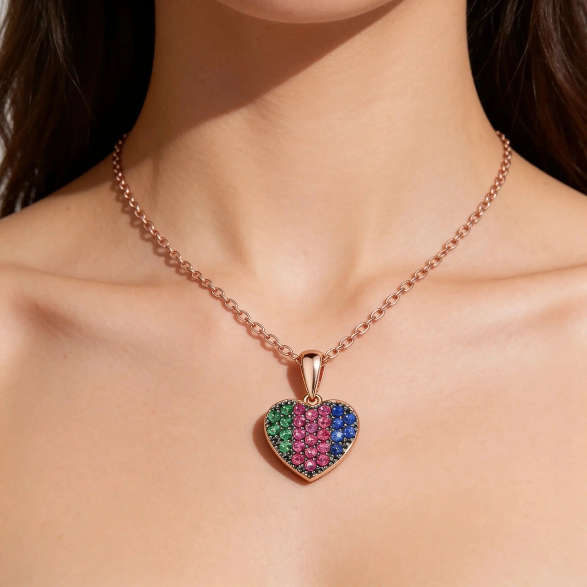 Rose gold heart necklace with multicolored stones on model's neck
