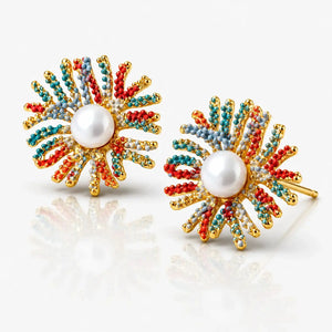 Colorful sunflower-shaped earrings with pearl center on a reflective surface