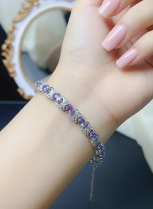 Natural tanzanite bracelet set in S925 sterling silver, ~7-inch adjustable tennis style with lobster clasp, blue-violet gemstones.