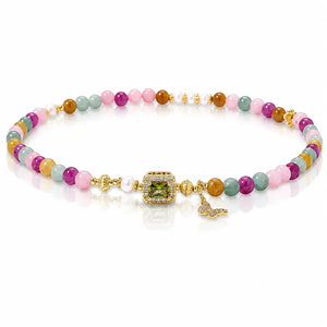 A multicolor beaded bracelet with gold-plated metal details, featuring a central green gemstone, a small white pearl, and a butterfly charm, displayed on a clean white background.