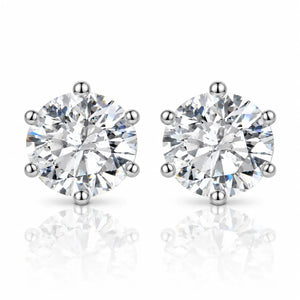 A pair of round-cut diamond stud earrings in a six-prong setting, shown on a clean white background with soft reflections below.