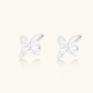 White butterfly-shaped earrings on a white background