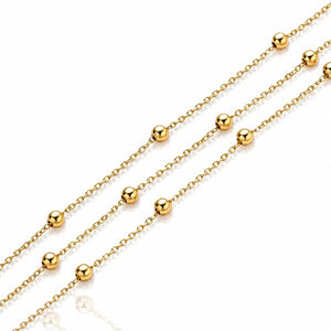 Gold chain necklace with evenly spaced round bead links, shown diagonally on a clean white background.