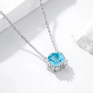 Silver gold plated necklace with oval blue topaz halo pendant on white background