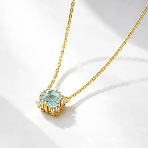 Gold plated necklace with round blue gemstone pendant and small clear crystals