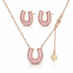 Rose gold jewelry set featuring a horseshoe-shaped pendant necklace, matching stud earrings, and a small clover charm on a delicate chain, displayed on a clean white background.