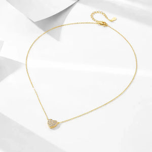 Gold necklace with a heart-shaped pendant on a white background