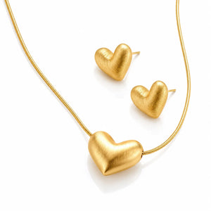 Gold heart-shaped necklace and earrings on a white background