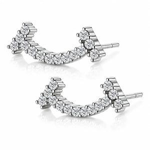 A pair of silver-toned curved stud earrings set with clear round-cut gemstones, displayed on a clean white background with soft reflections.