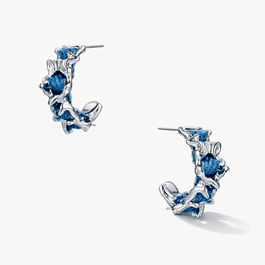 White gold plated hoop earrings with textured silver design and woven denim blue accents