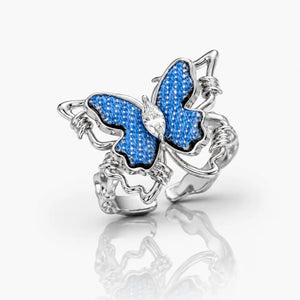 Butterfly-shaped jewelry charm with blue and silver design on a white background