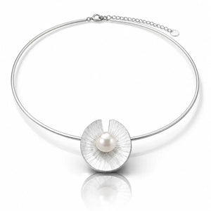 A silver-toned bangle necklace featuring a textured, petal-like circular pendant with a single white pearl at its center, displayed on a clean white background with a soft reflection.