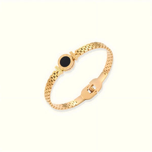 Gold bracelet with a black center stone on a white background