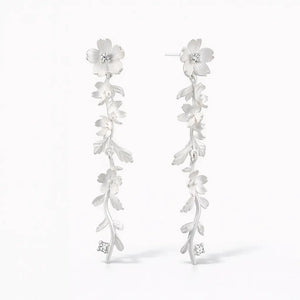 Silver drop earrings with intricate floral and leaf design, accented with sparkling stones
