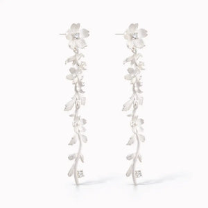 Silver drop earrings with floral vine design and delicate crystal accents on white background