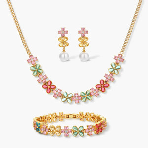 Floral jewelry set with gold necklace, bracelet, and earrings featuring colorful enamel flowers and pink gemstones