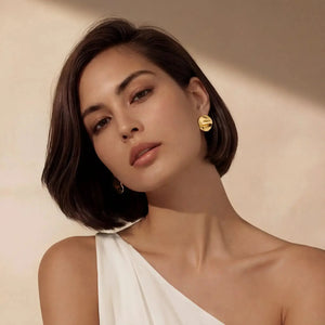 Woman wearing elegant 18K gold plated sterling silver stud earrings, minimalist style