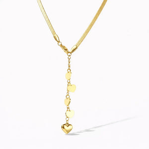 14K gold Y necklace with cascading heart charms on a white background