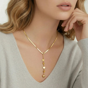 Woman wearing 14K gold Y necklace with cascading heart charms, elegant jewelry style