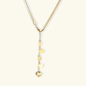 Gold necklace with heart-shaped pendants on a white background