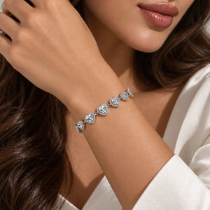 A close-up lifestyle shot of a woman wearing a silver-toned bracelet adorned with five round-cut clear gemstones, set against her shoulder and hair.
