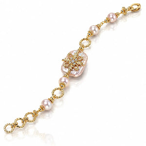 A gold chain bracelet featuring a large baroque pearl at the center, accented by smaller round pearls and twisted gold links, displayed on a clean white background.