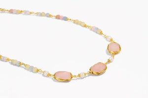 Necklace with pink stones and gold chain on a white background