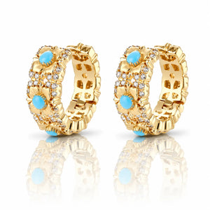 Gold hoop earrings with blue gemstones on a white background