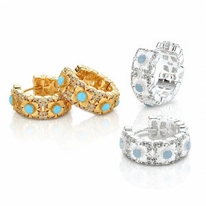 Pair of gold hoop earrings with blue stones and a silver hoop earring on a white background