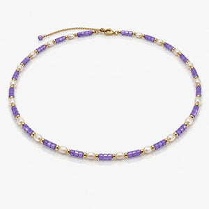 Necklace with purple and gold beads on a white background